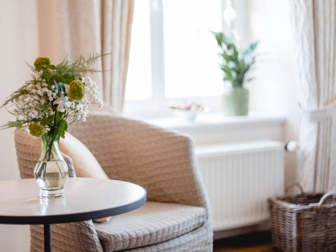 Ein stilvoller Stuhl, dekoriert mit einer Vase, die mit leuchtenden Blumen gefüllt ist und Freude ausstrahlt.