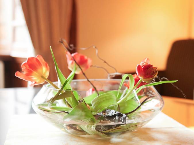 Warm beleuchteter Empfangsbereich mit Tulpen in einer Glasschale