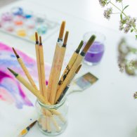 Ein Tisch mit Pinsel und Blumen, der die kreative Atmosphäre der Zeichentherapie widerspiegelt.